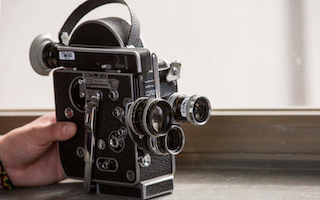 Film camera with a hand on it